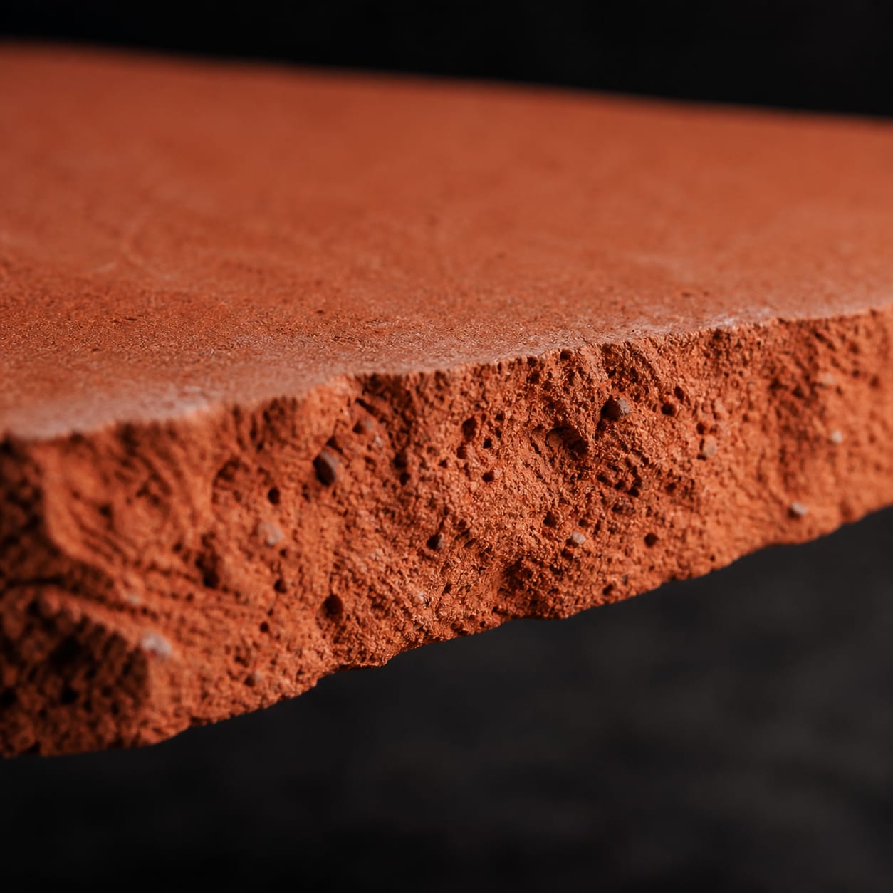 The cut edge of the unglazed terracotta tile used on the counter fronts