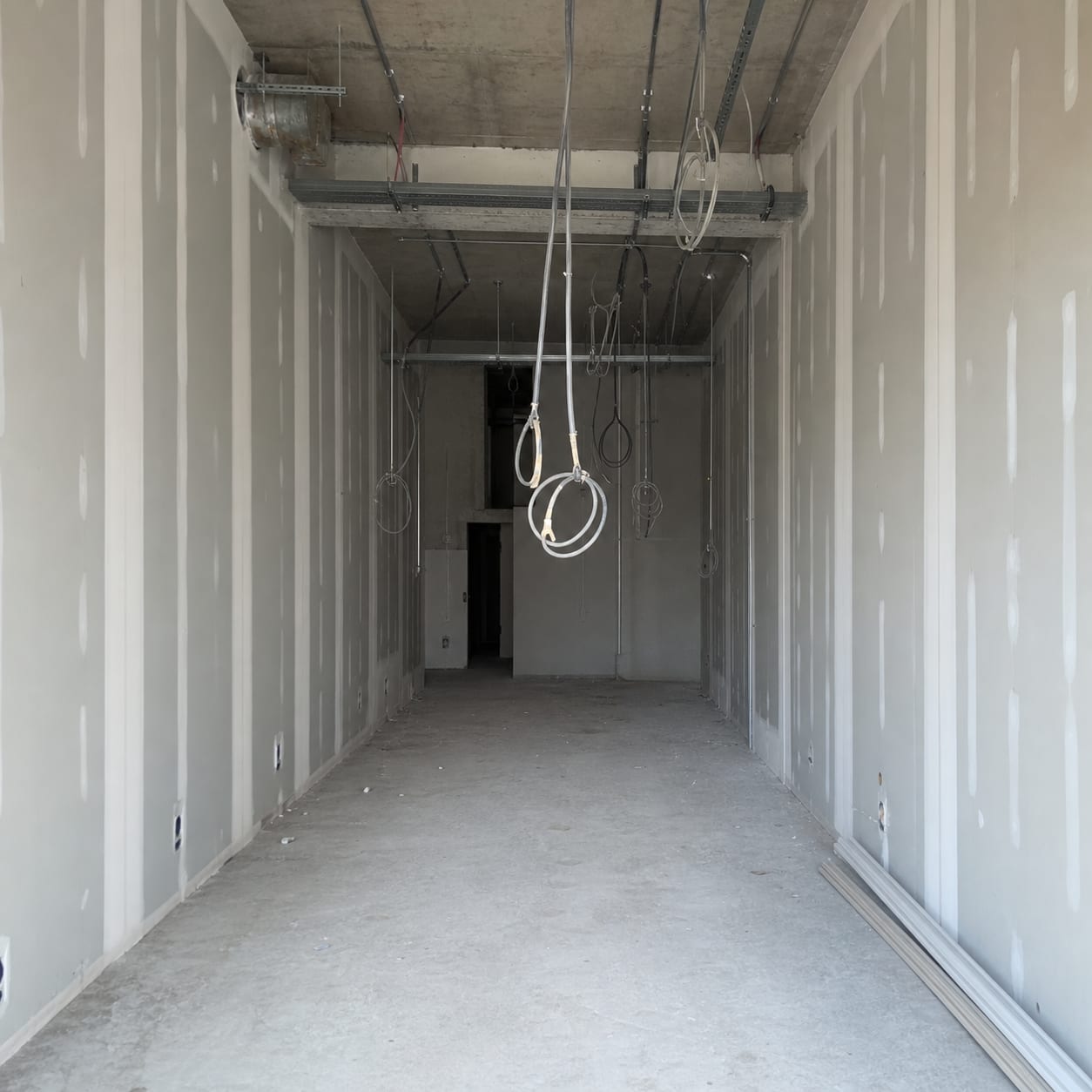 Kakato before works. A narrow unit with conduit still hanging from the ceiling