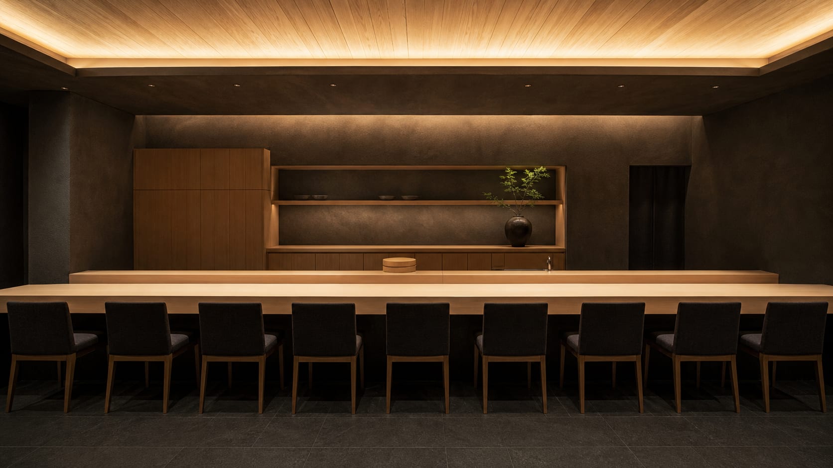 The counter at Shiraki Ichimai. One unbroken hinoki slab for nine seats, lit from a cove above