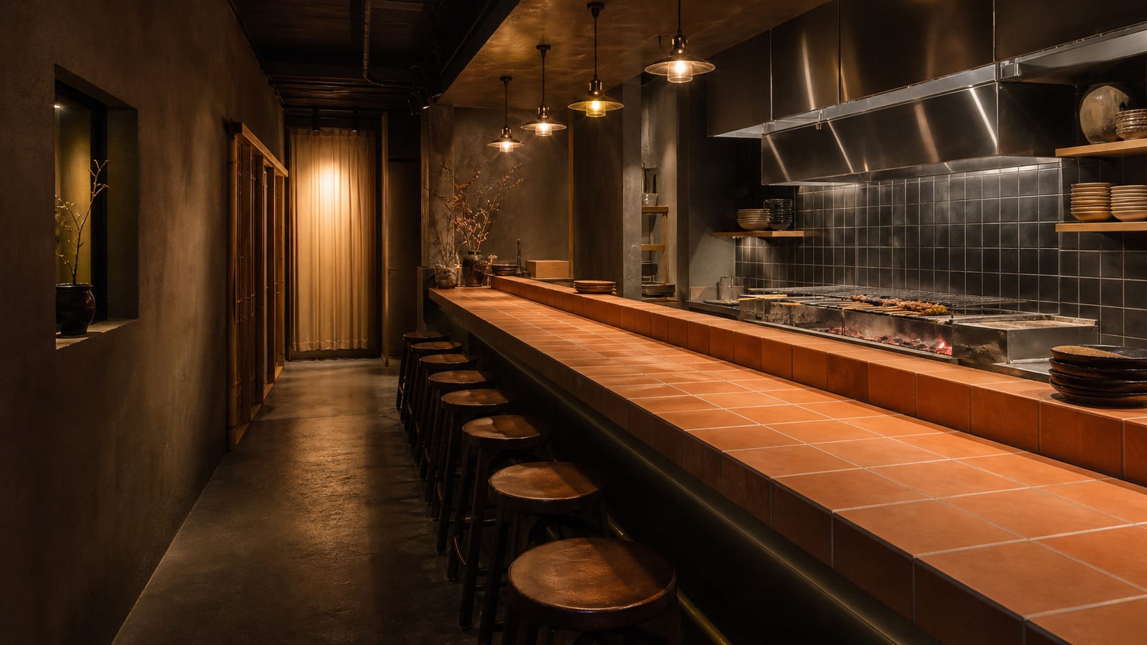 Toro on handover day. A terracotta tile counter running to the charcoal grill, with a brass footrail below
