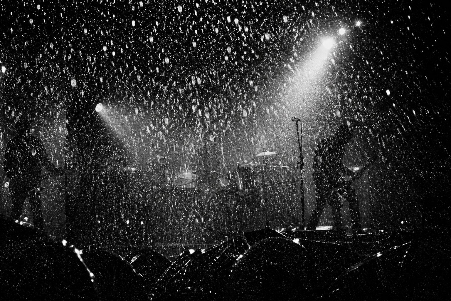 雨の野外ステージ。ストロボに照らされた雨粒が画面いっぱいに白い点として写る